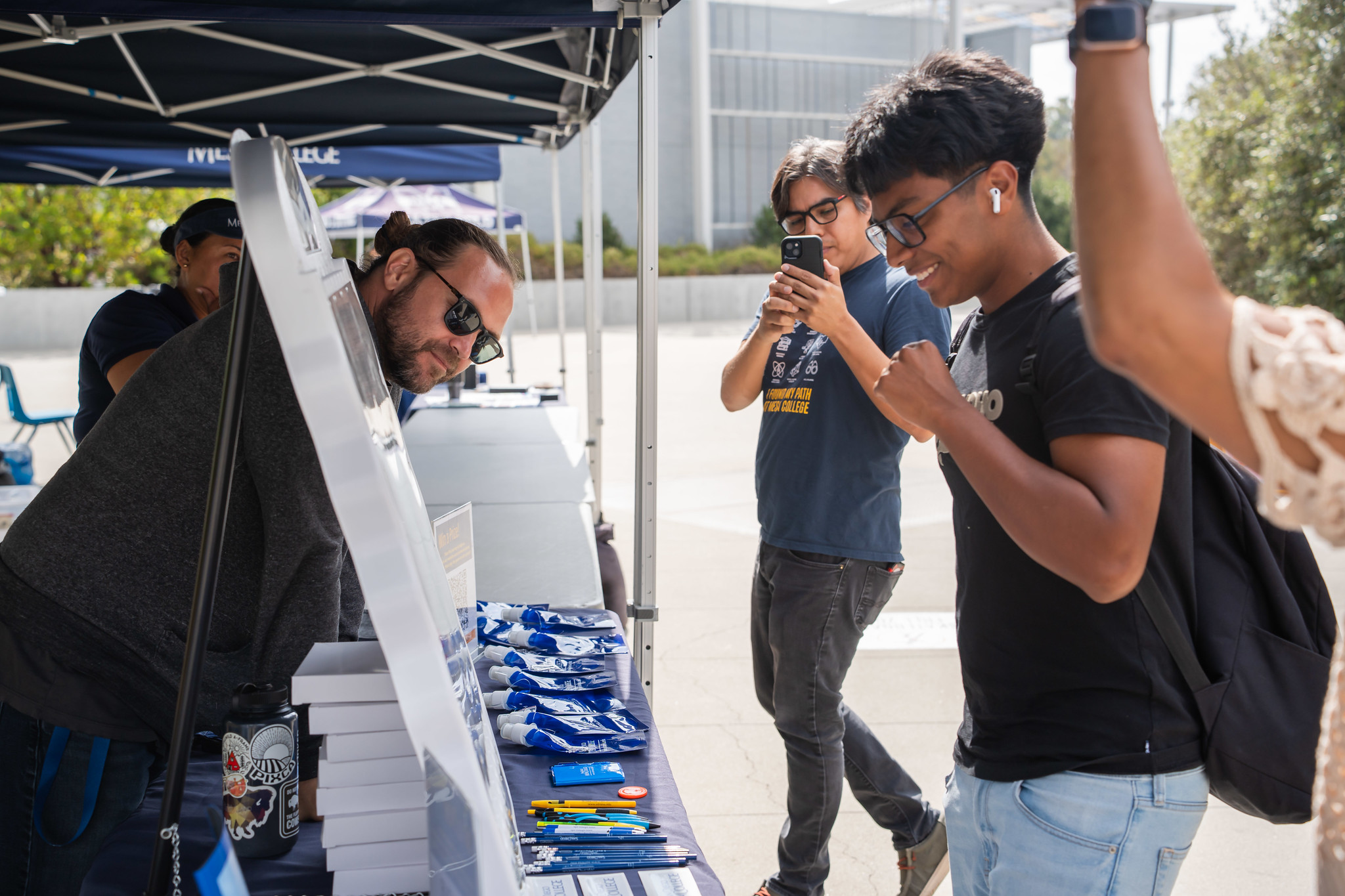 
A student at a welcome tent uses a plinko board to win a prize.
