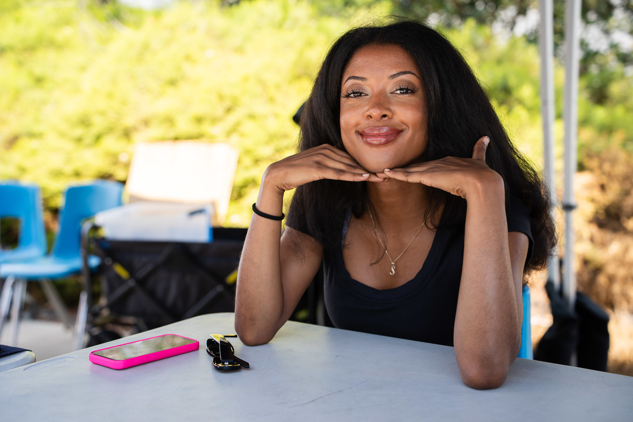 
A woman smiling and sitting under a welcome tent.
