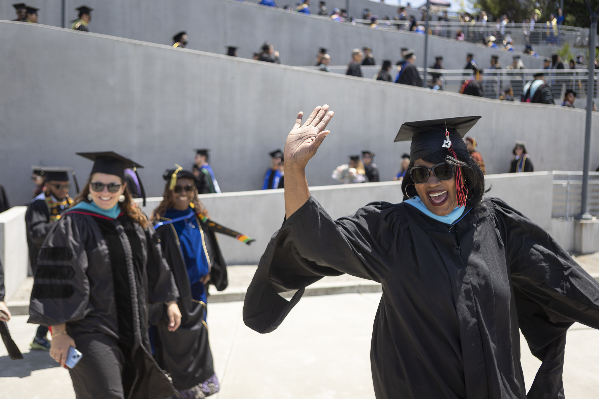 
A graduate waves to the crowd as she heads to her seat.
