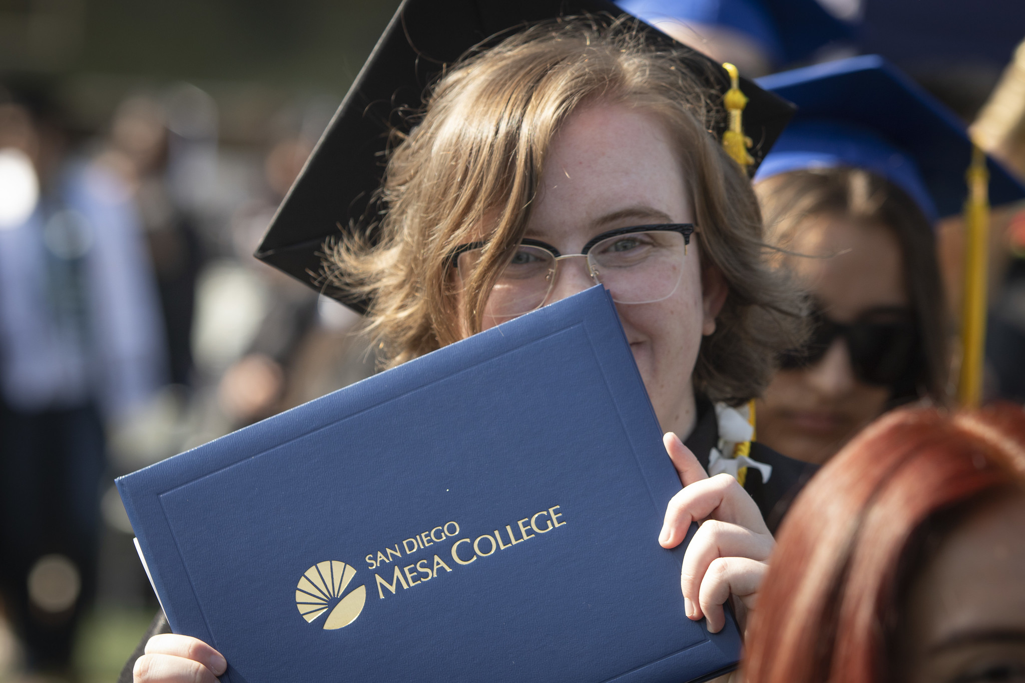 
A graduate holds up her degree.
