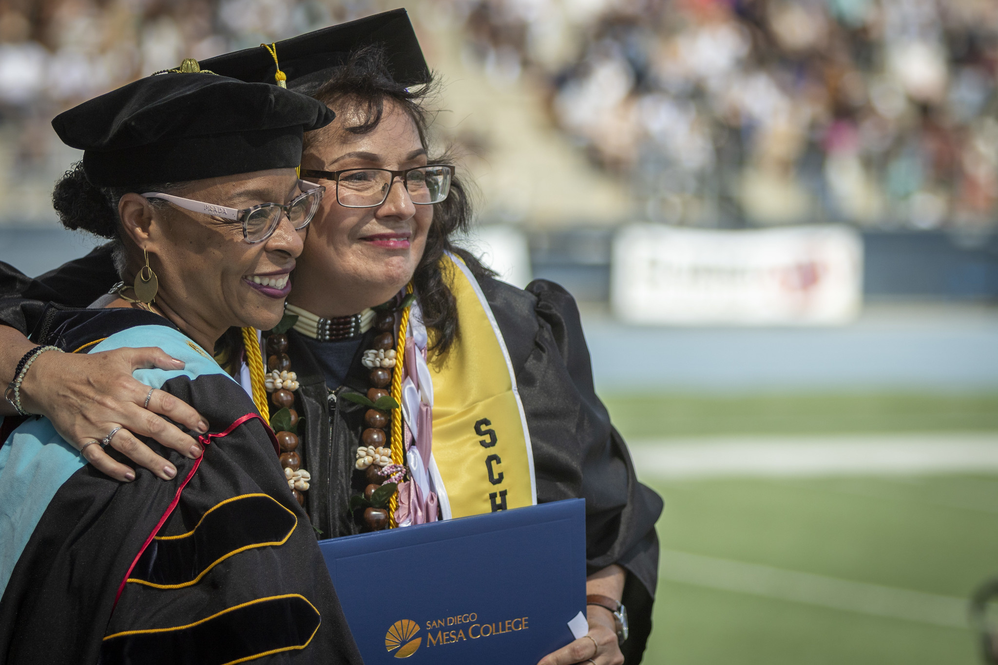 
Mesa College President Ashanti Hands hugs a graduate who just received her diploma.
