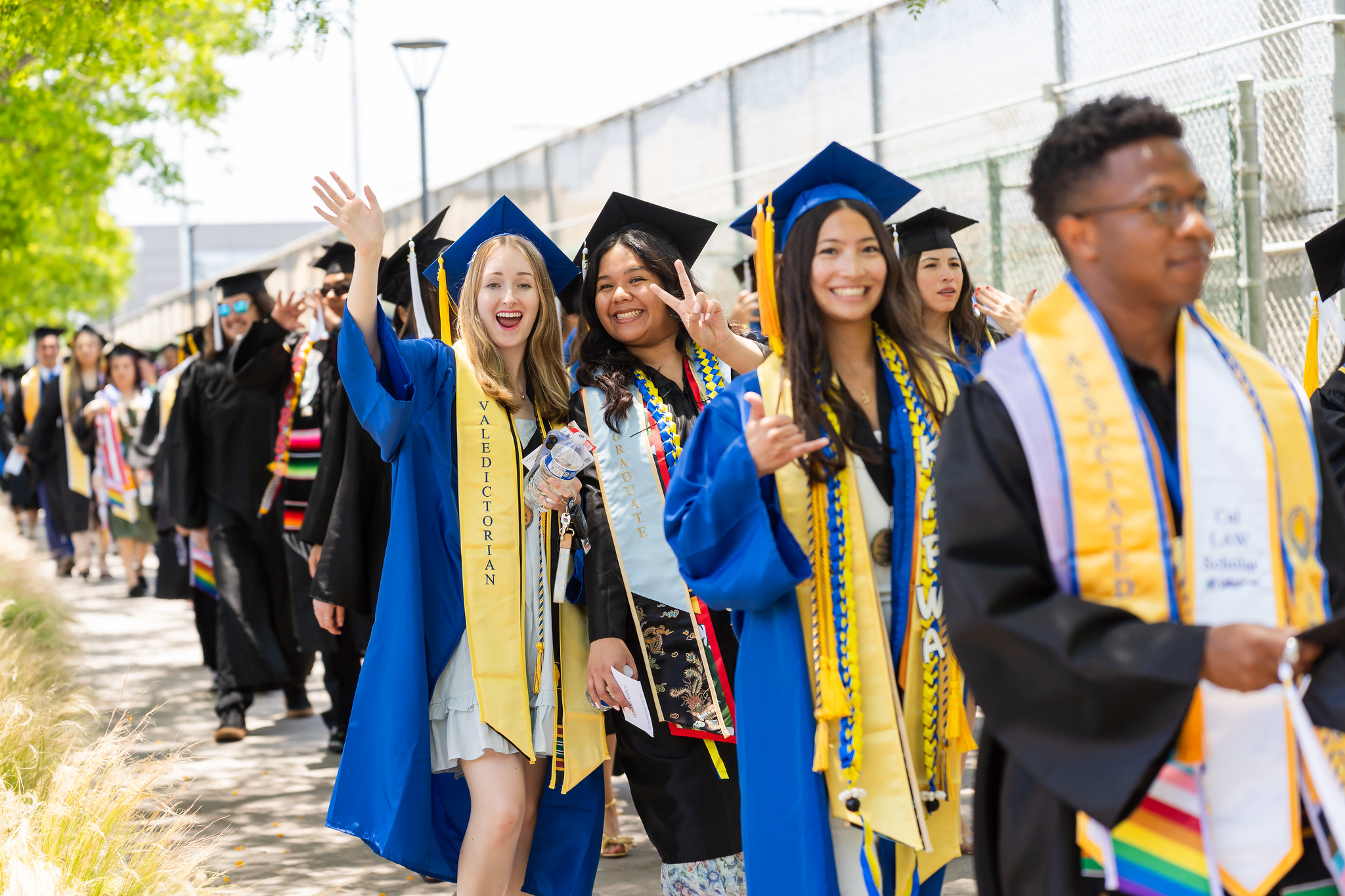 
Graduates wave as they line up to walk into the commencement ceremony.
