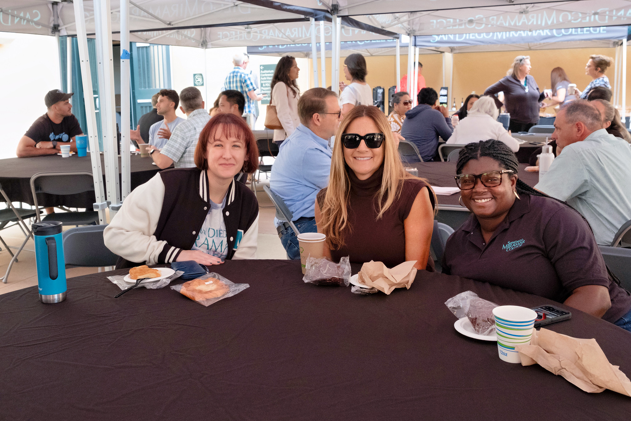 
Three people at a table for lunch at convocation.
