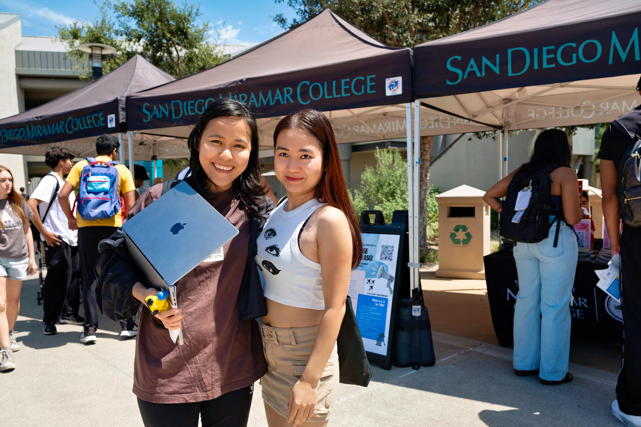 
Two students in front of a row of welcome booths.
