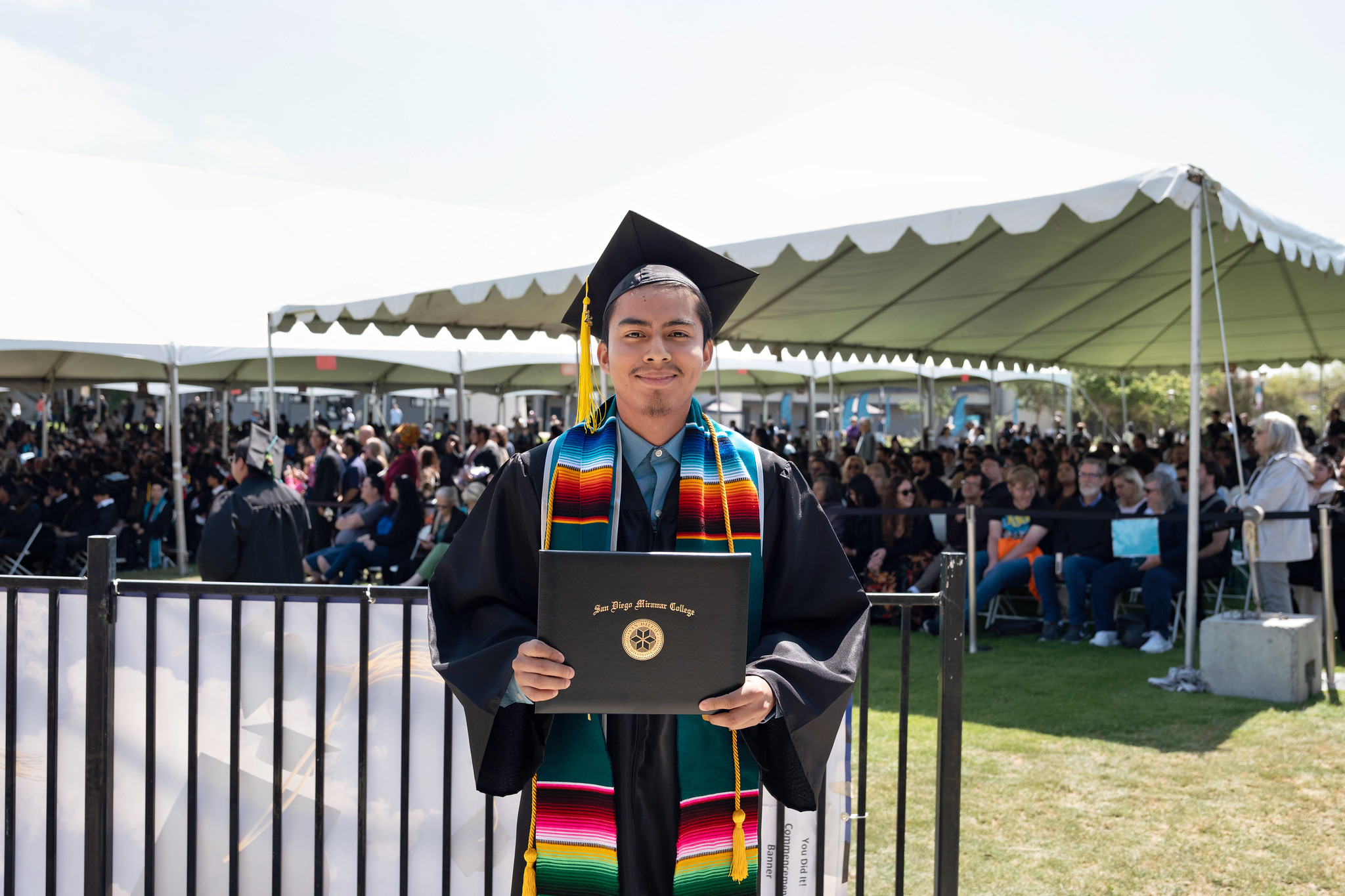 
A student holds up his degree.
