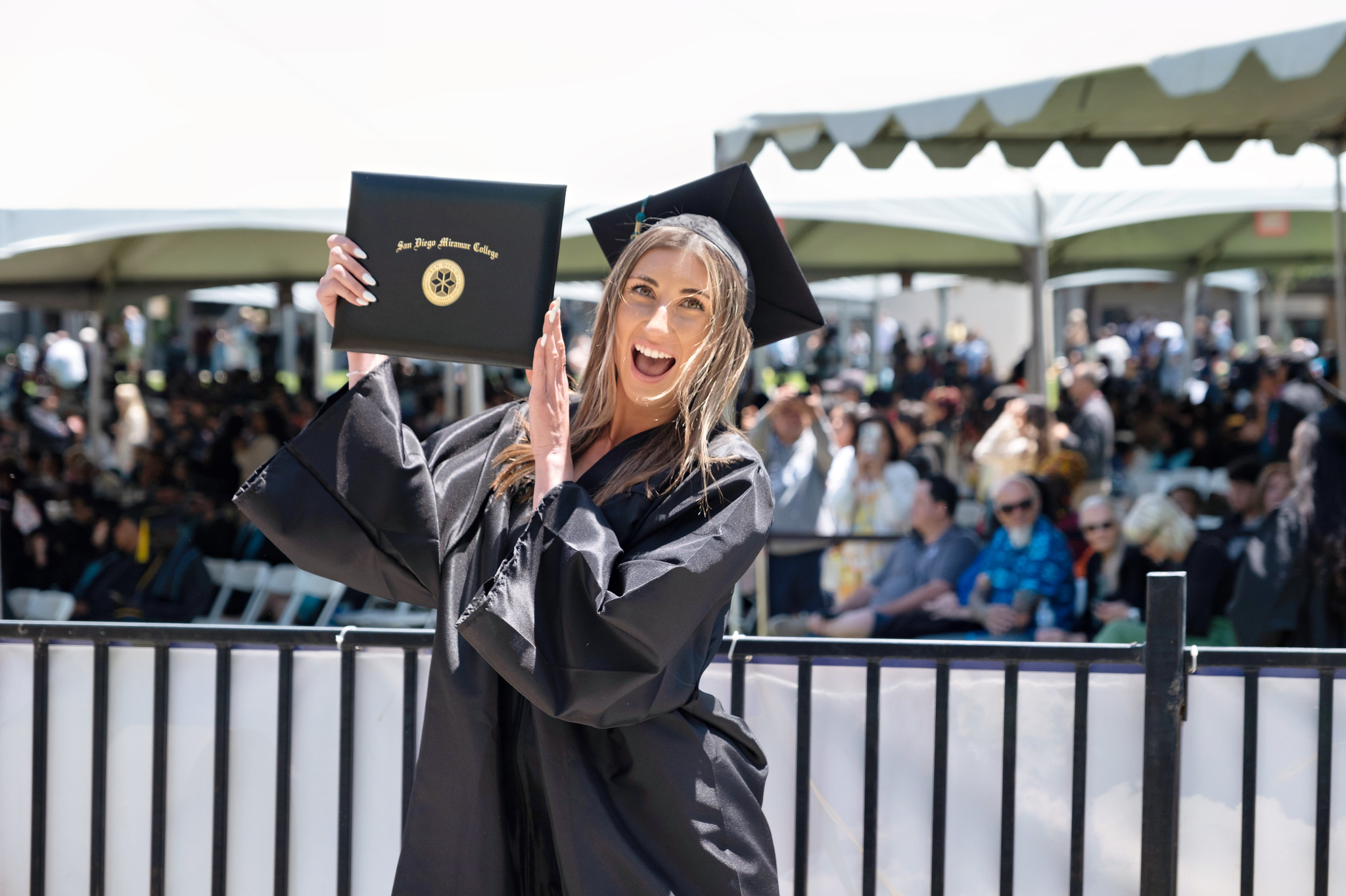 
A graduate is holding up her degree.
