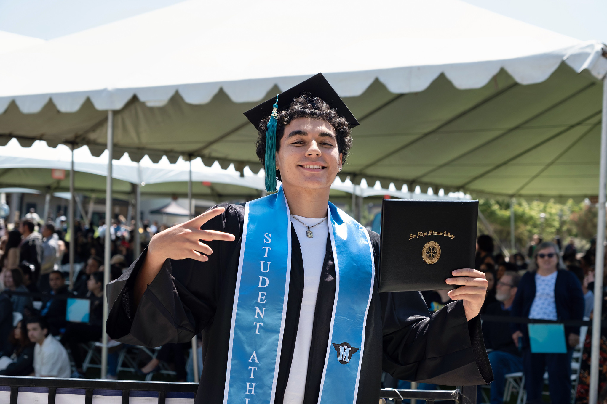 
A graduate holds up his degree.
