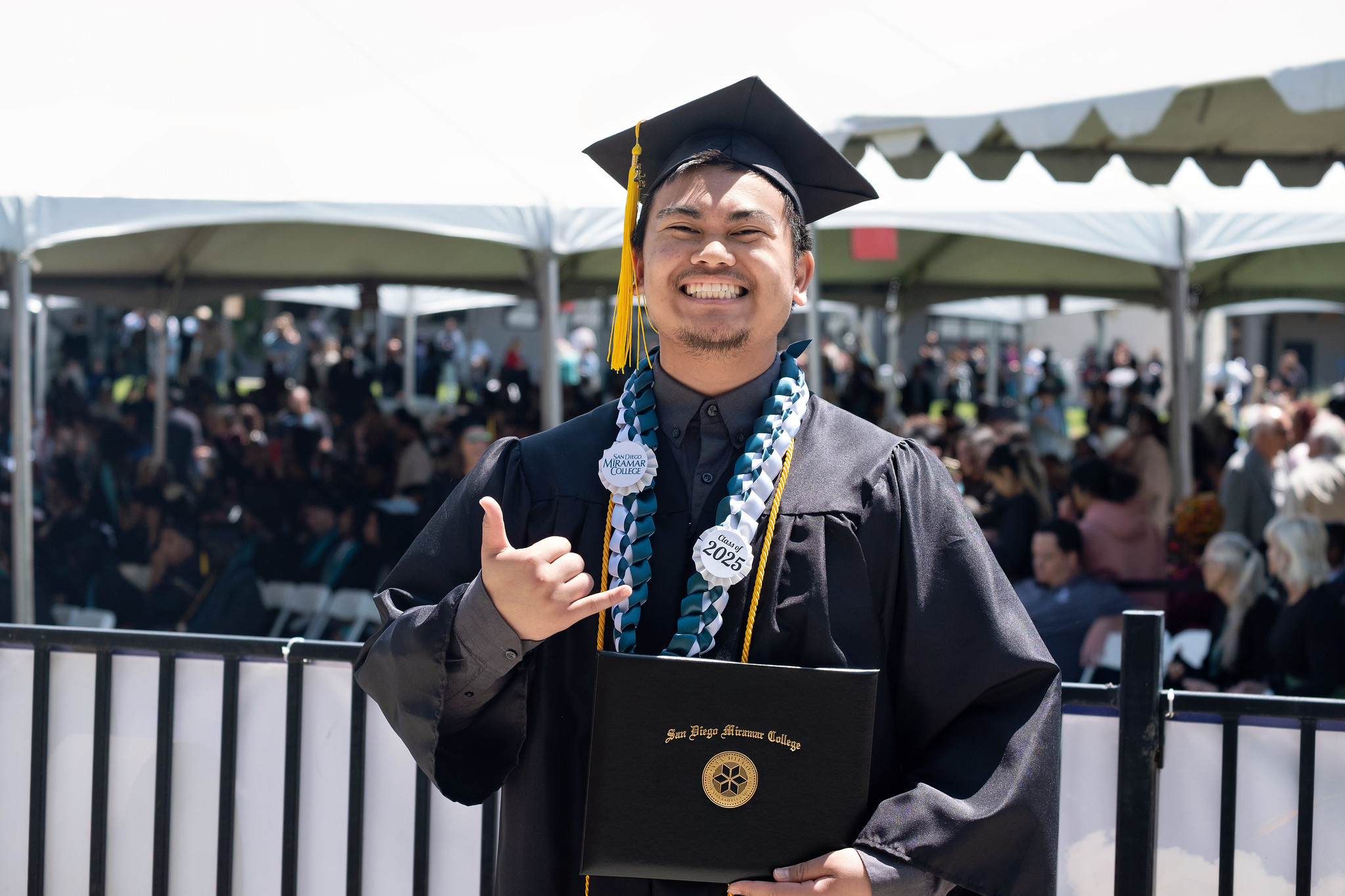 
A graduate holds up his degree.
