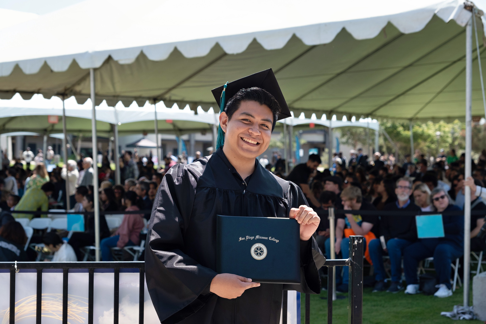 
A graduate holds up his degree.
