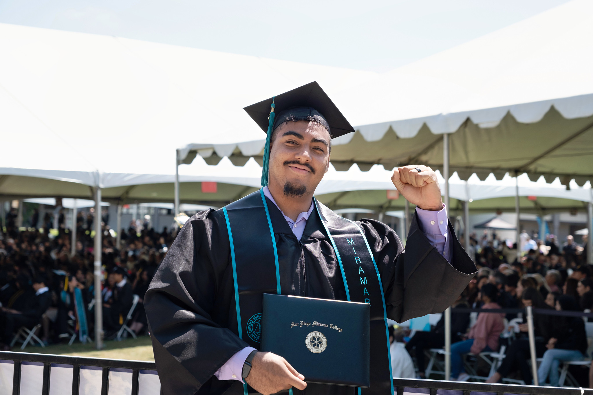 
A graduate holds up his degree.
