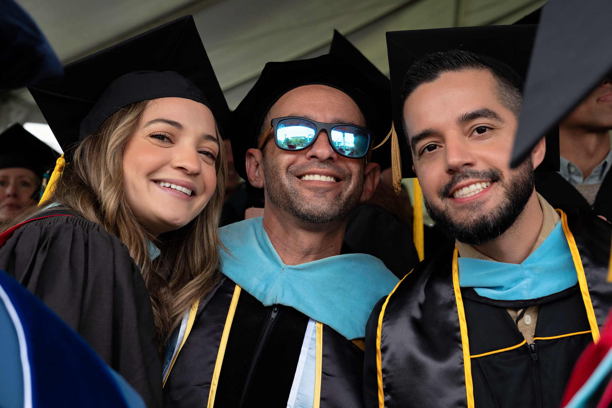 
Three faculty members in caps and gowns at commencement.
