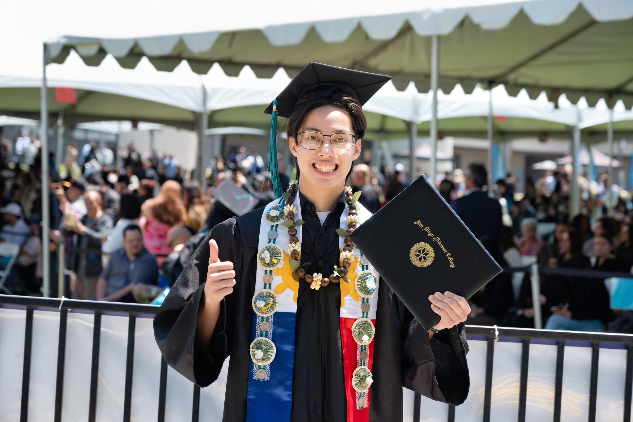 
A graduate holds up his degree.
