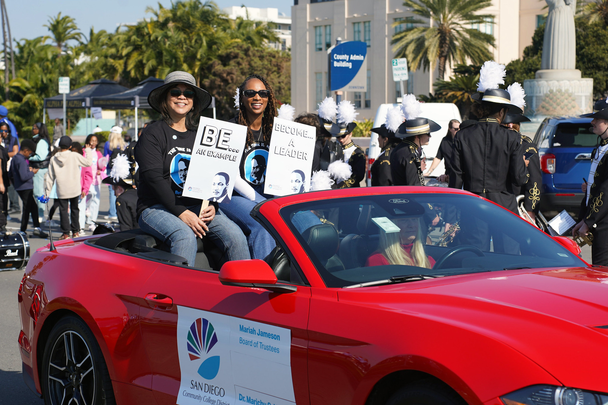 Trustees Marichu Magana and Mariah Jameson ride in a red convertible in the parade.