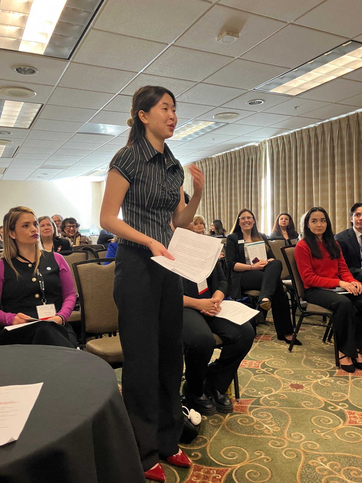 
A student trustee is standing and speaking at a meeting.
