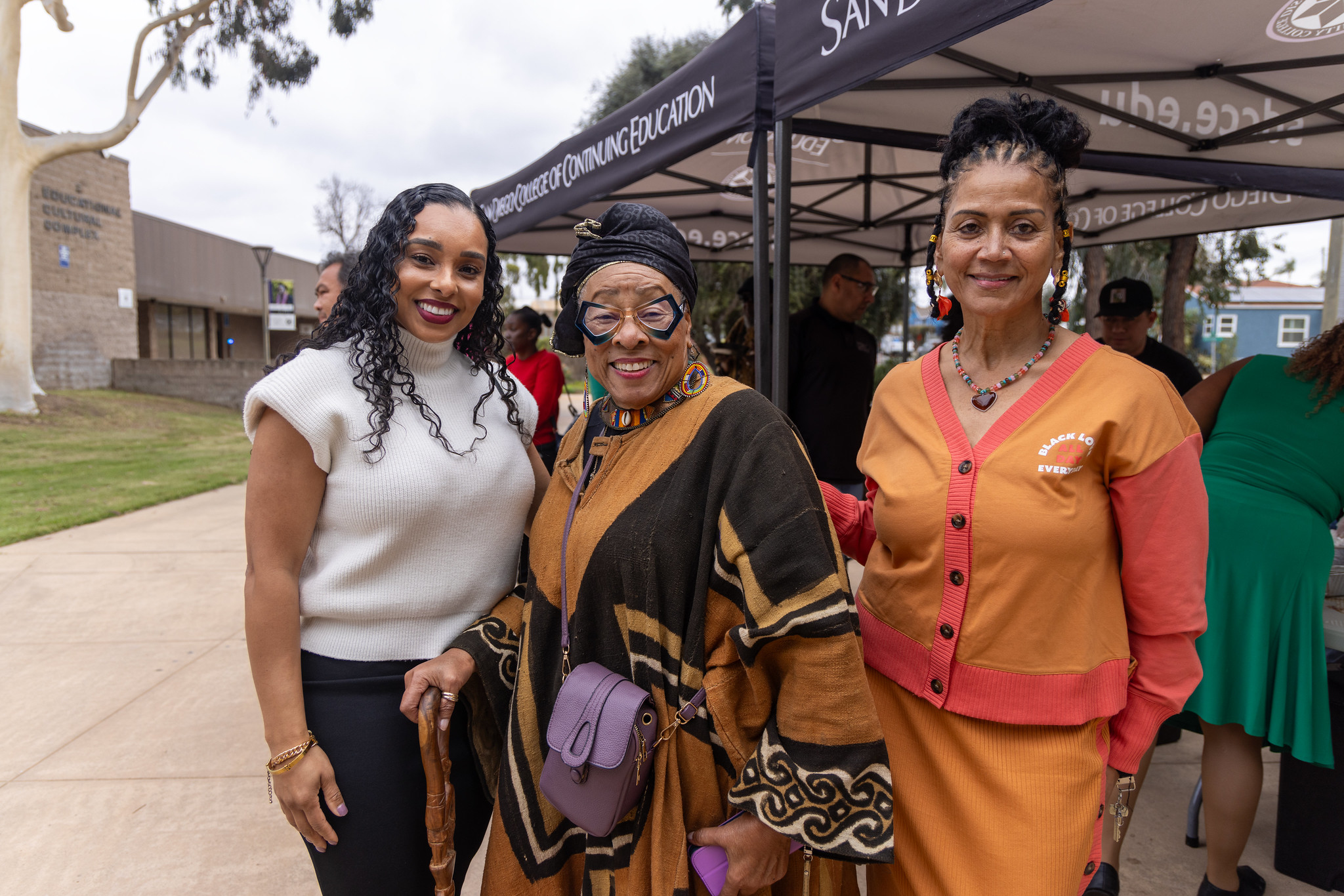 
College of Continuing Education President Tina King with two ladies at a welcome booth at the Educational Cultural Complex.
