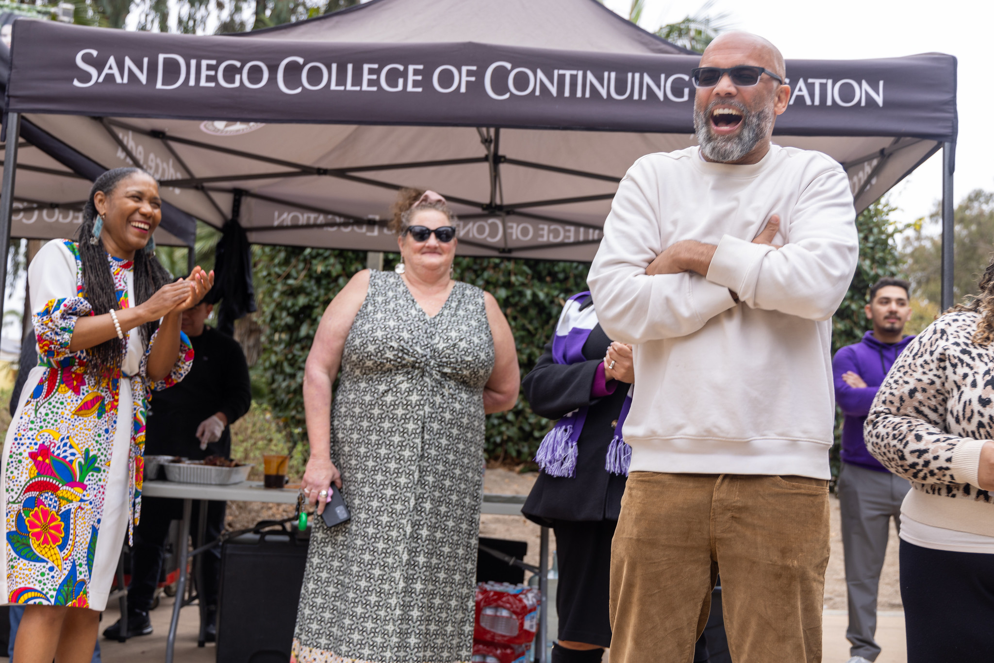 
Three people laughing and smiling in front of a booth during a Black History Month event at the ECC.
