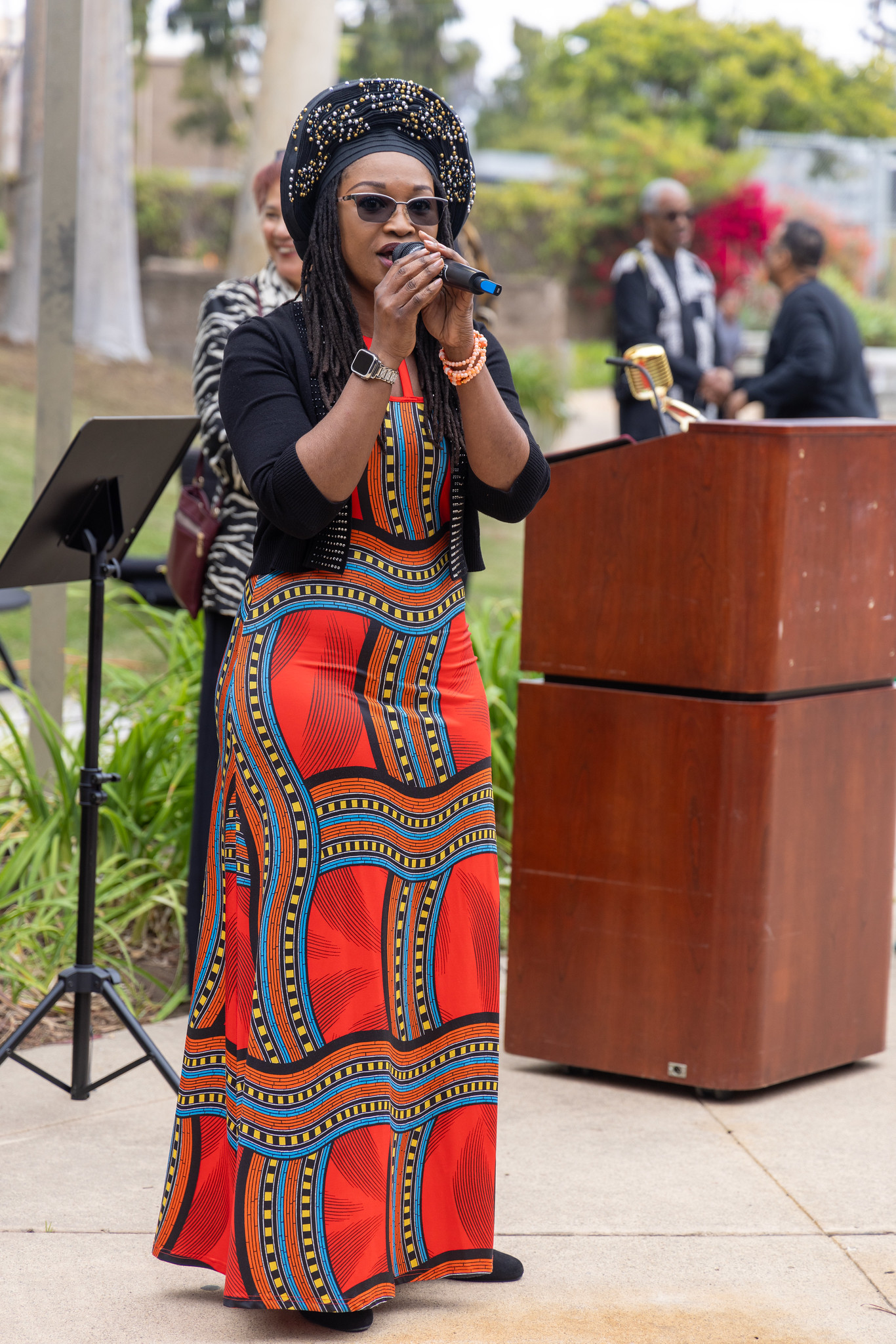 
A singer in a red dress and a black hat at a College of Continuing Education Black History Month event.
