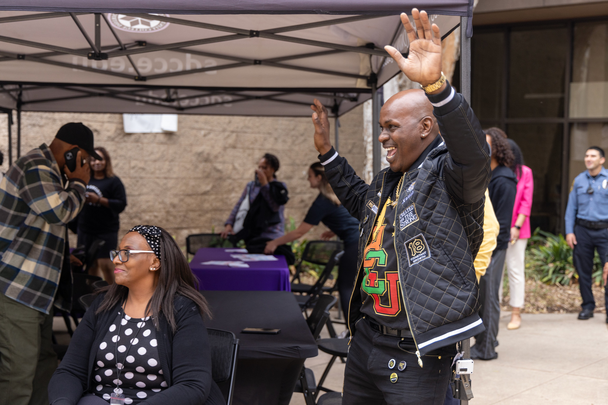 
A man smiling and holding up his hands as he looks on during a Black History Month event at ECC.
