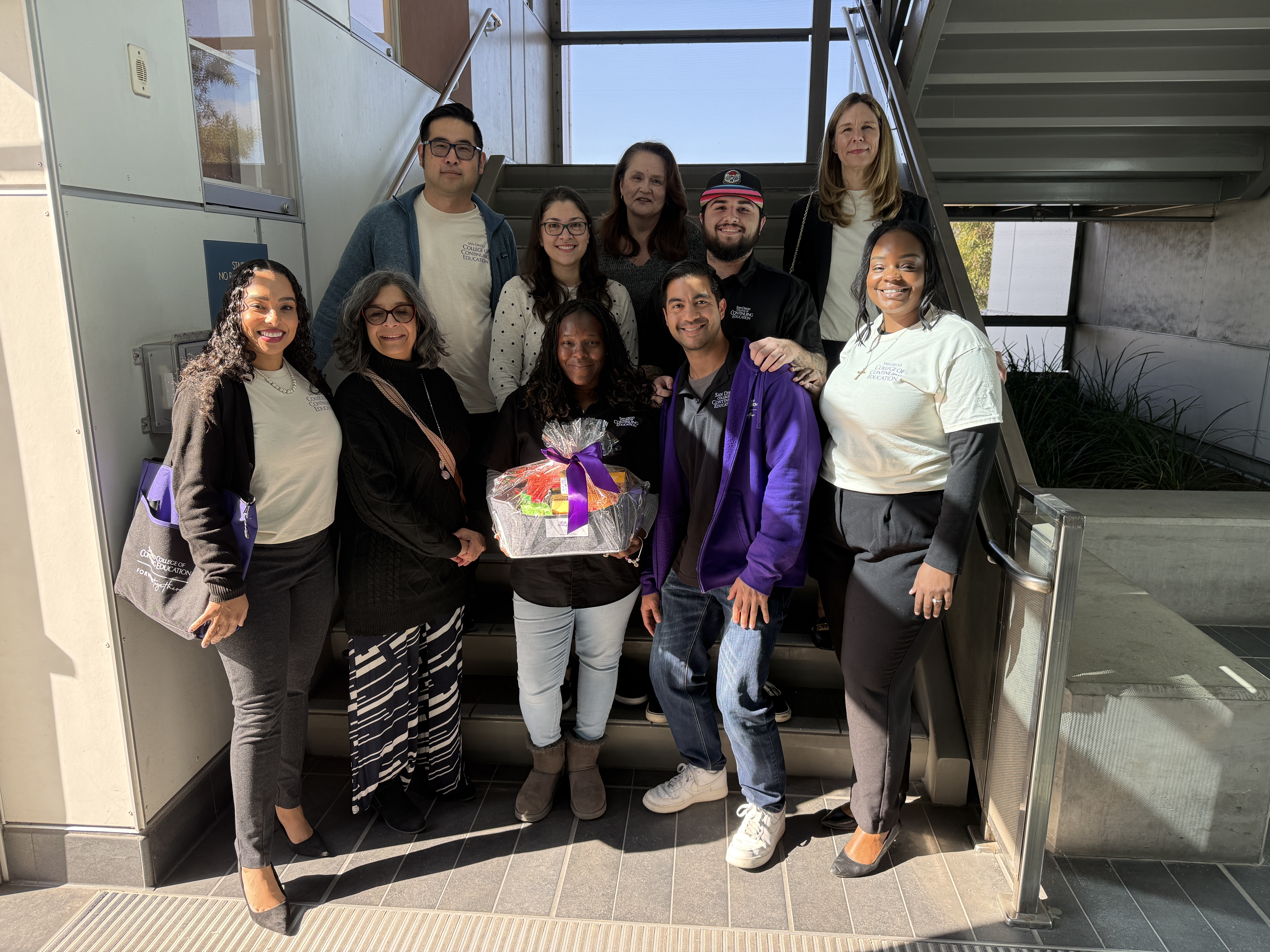 
College of Continuing Education President Tina King gives a welcome basket to nine employees at one of the college's campuses.
