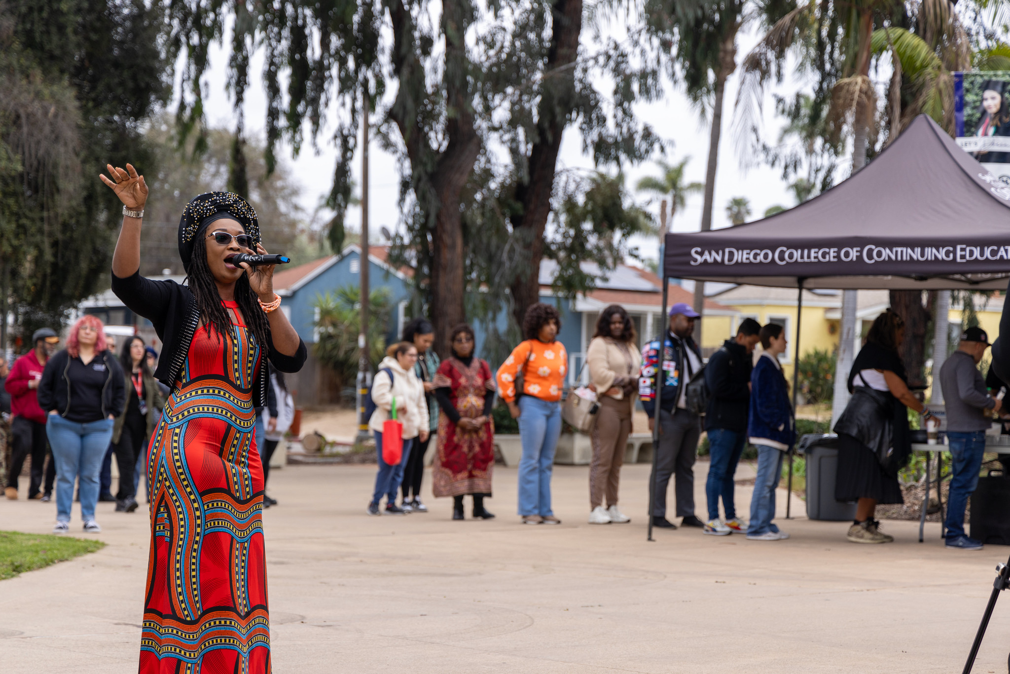 
A singer wearing a red dress and a black hat at a Black History Month event at the Educational Cultural Complex.

