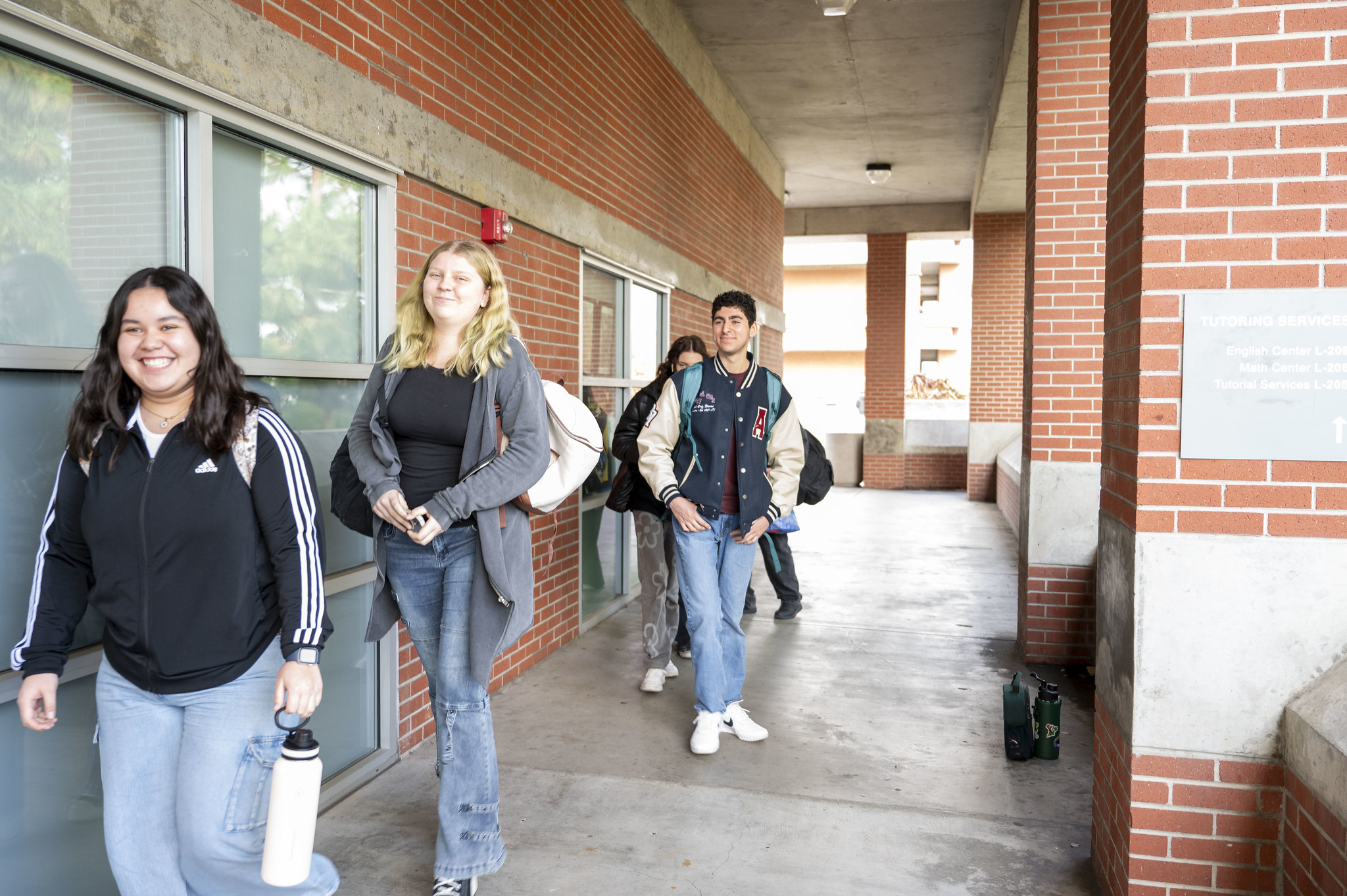 
Five City College students walking down a hallway near some classrooms.
