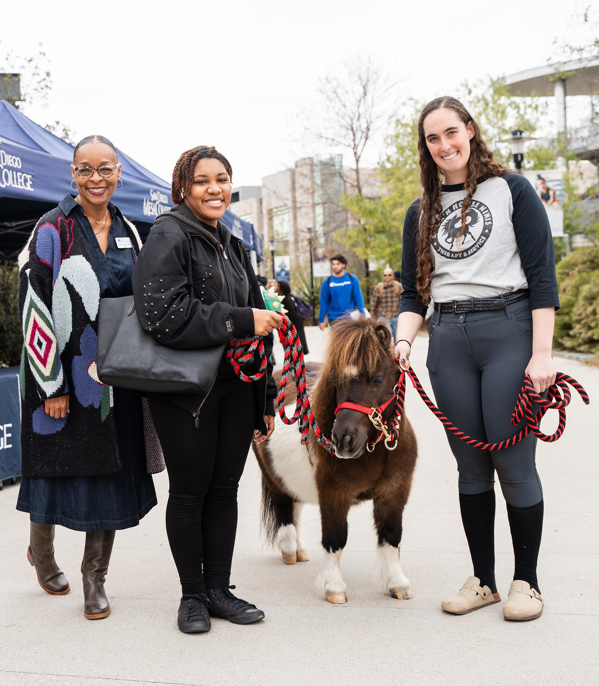 
Mesa College President Ashanti Hands with two ladies and a brown and white mini horse.
