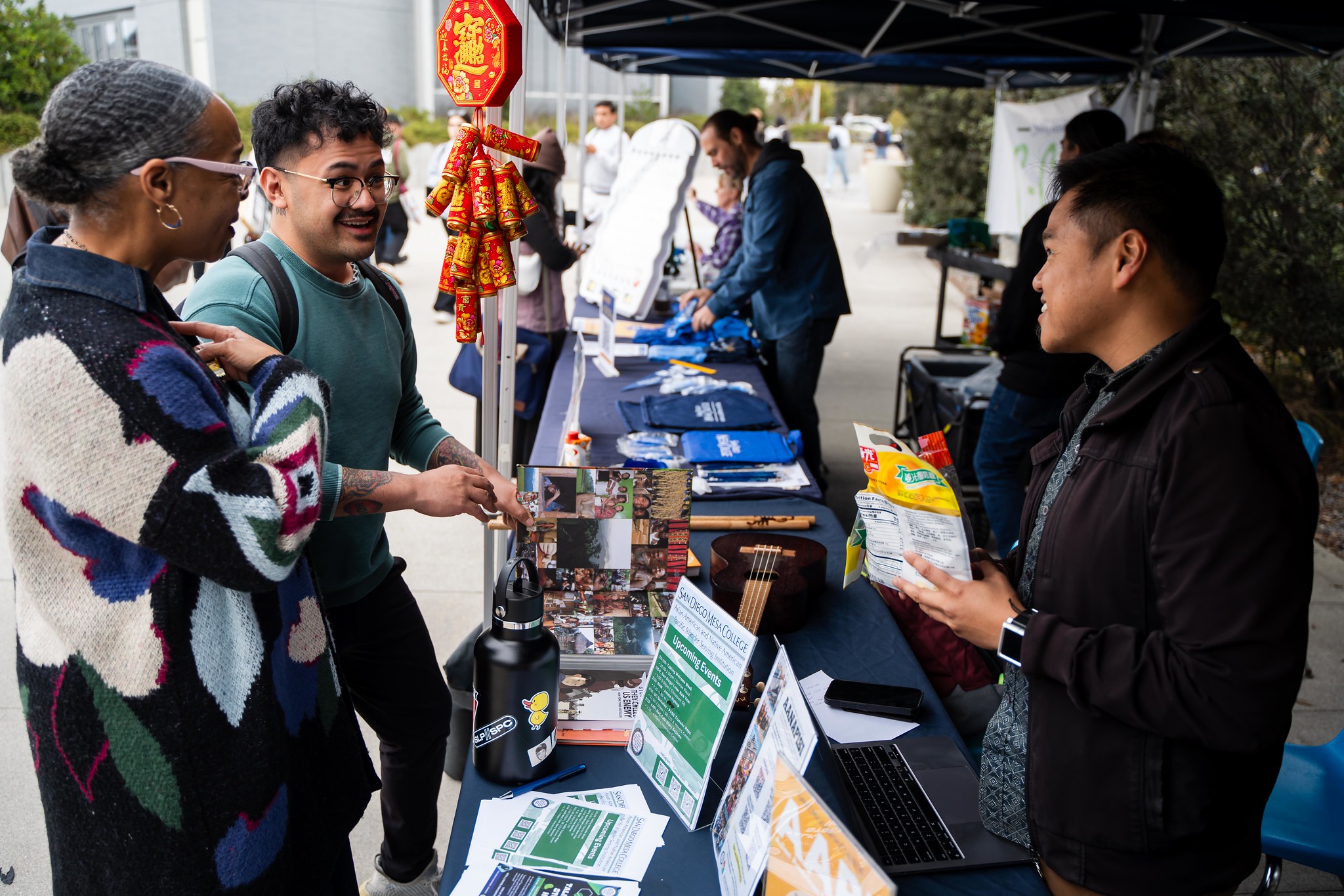 
Mesa College President Ashanti Hands at a booth with two students.
