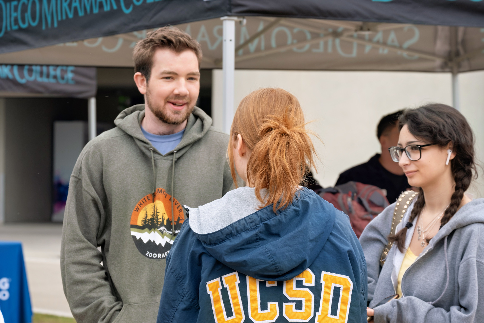 
Three people talking at Miramar's welcome week.
