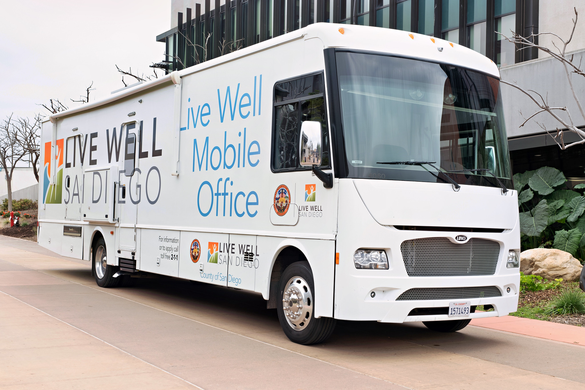 
A large white bus at Miramar College. The side of the bus says Live Well Mobile Office.

