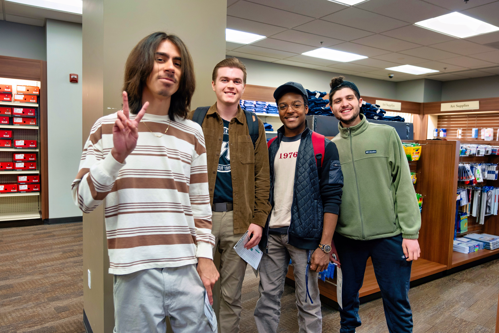 
Four students in the Miramar College bookstore. One is giving a peace sign.
