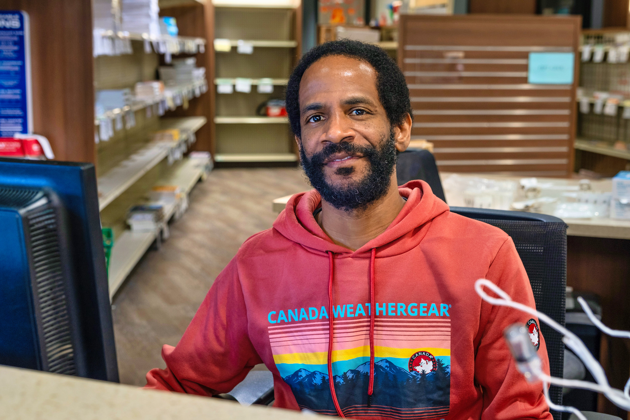 
A man in a red sweatshirt sitting at a computer at Miramar College.
