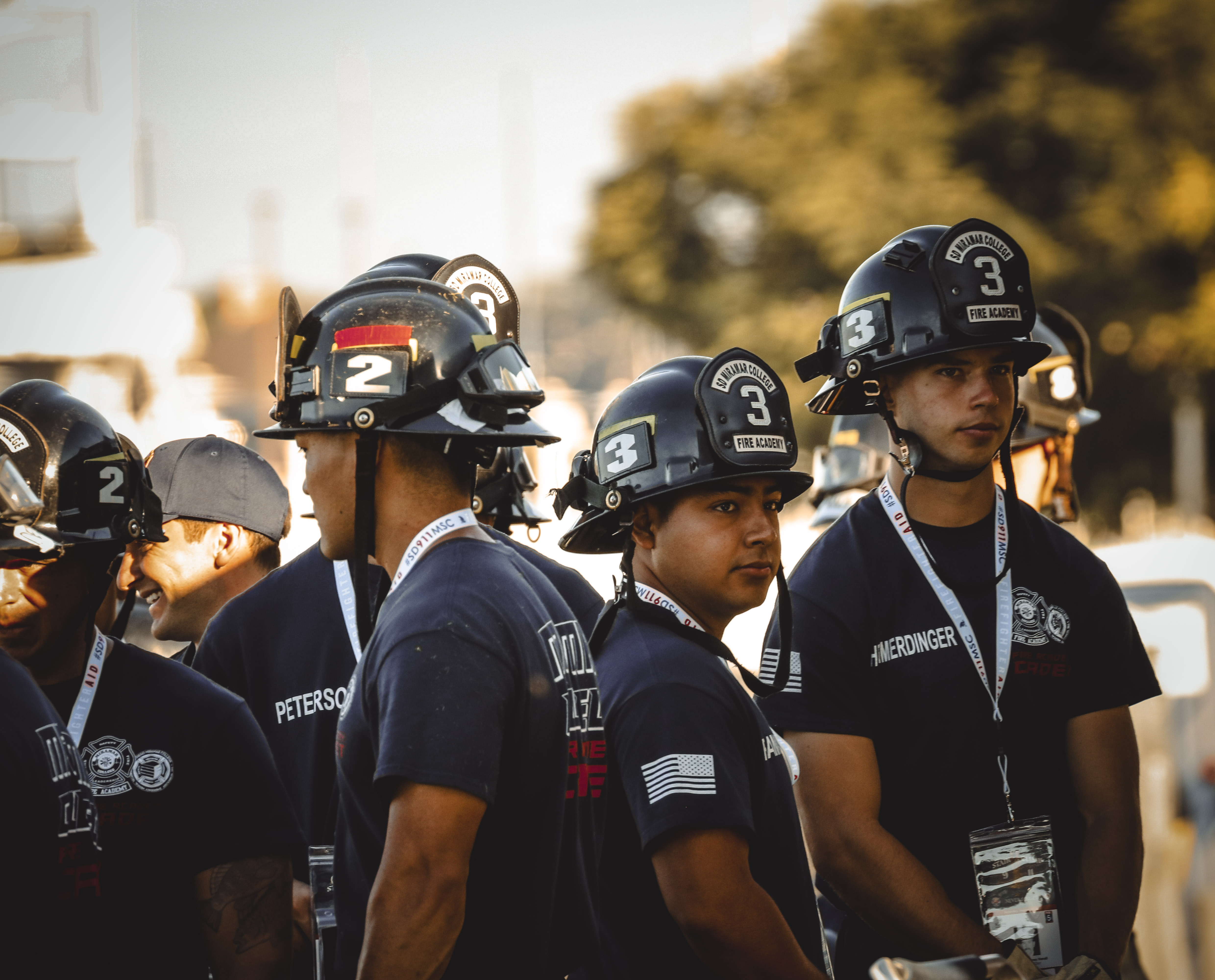 
Five cadets in dark blue fire academy t-shirts and black fire helmets.
