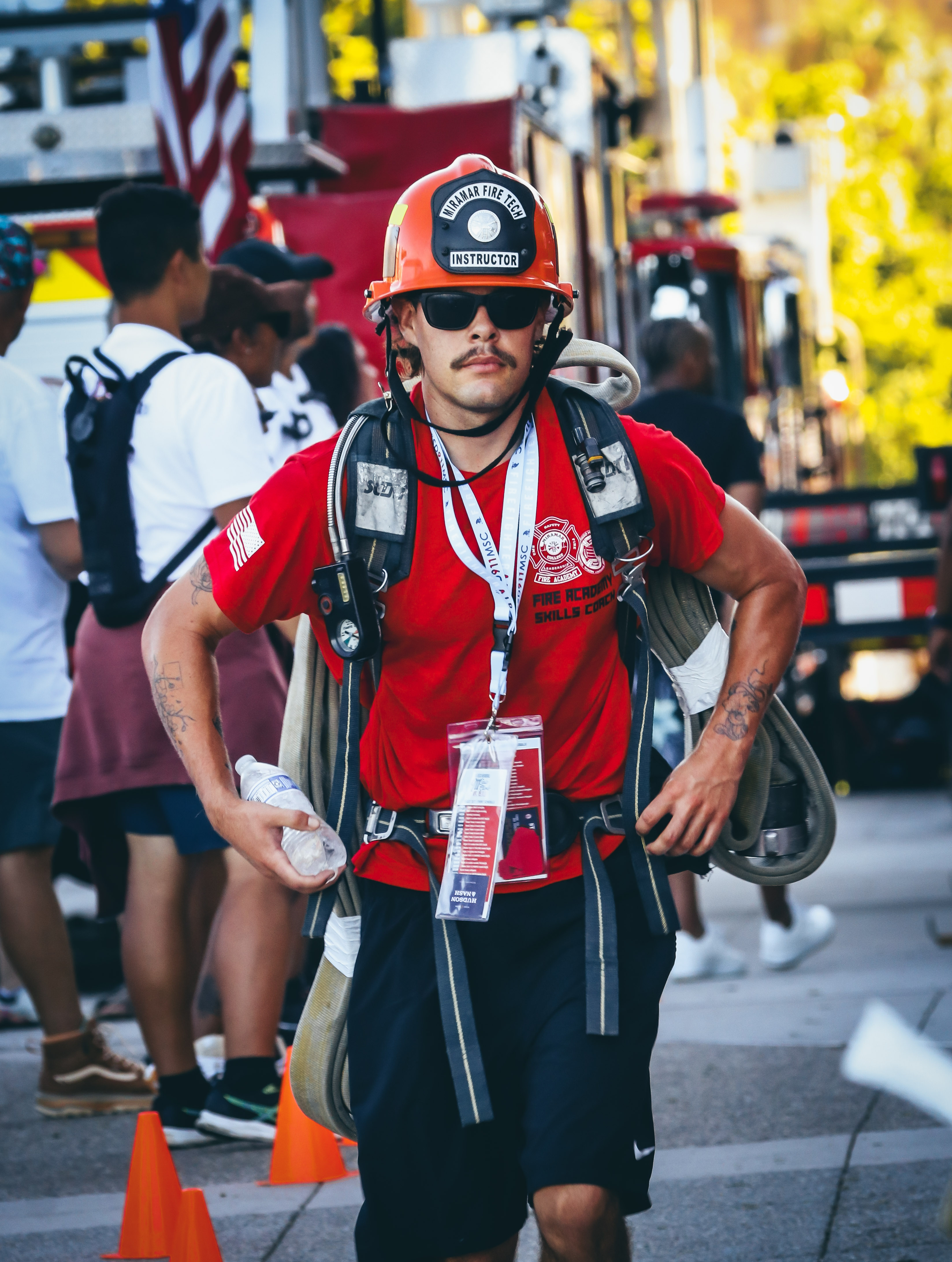 
A Fire Academy instructor wearing a red shirt, a red fire helmet and fire gear nears the finish line.&nbsp;
