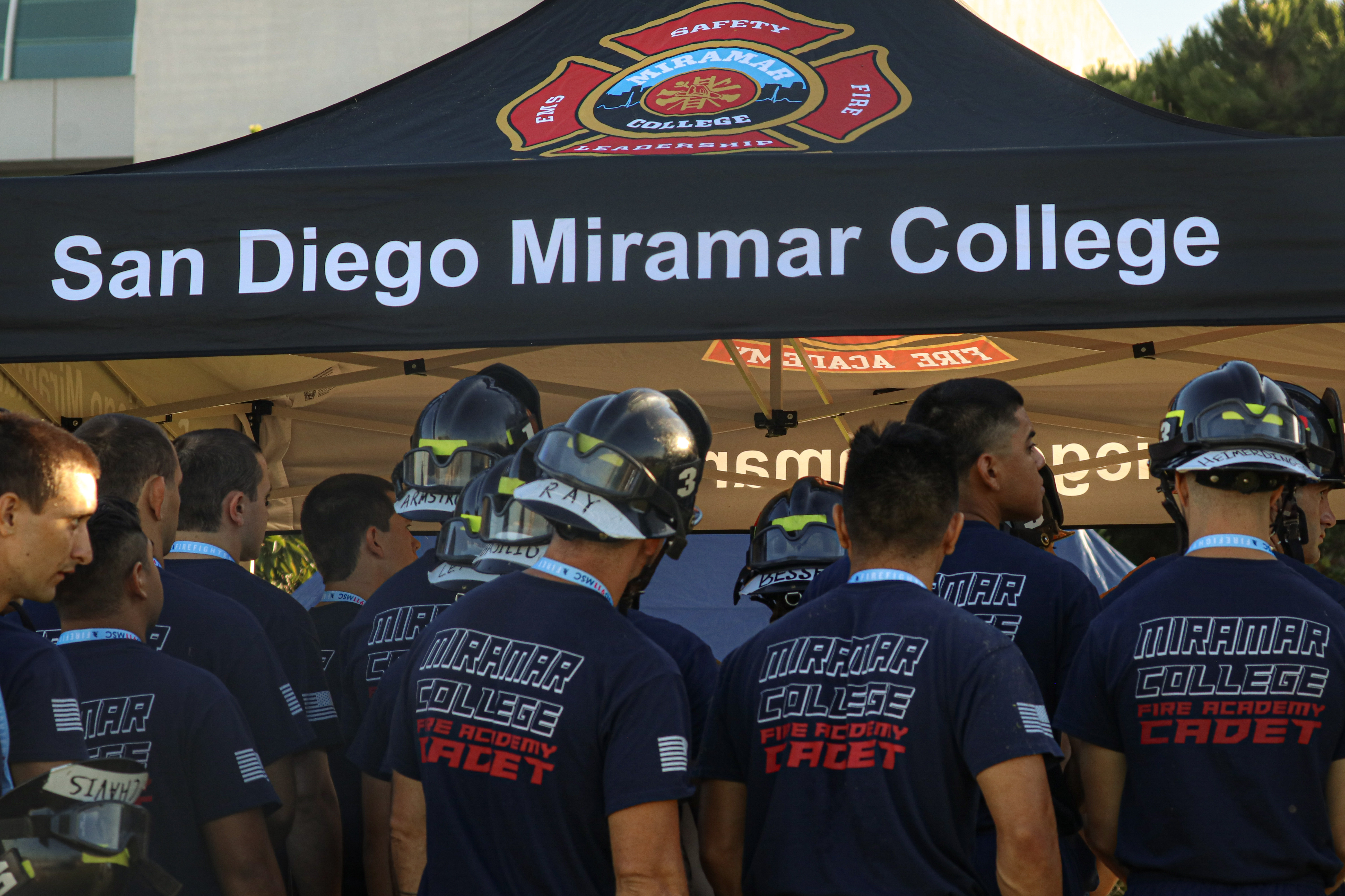 
Cadets in Miramar Fire Academy shirts gather by a Miramar tent at the stair climb.

