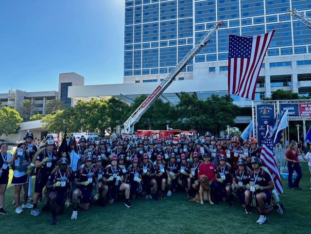 
Miramar College's Fire Academy cadets and instructors take a group photo under an American flag. .
