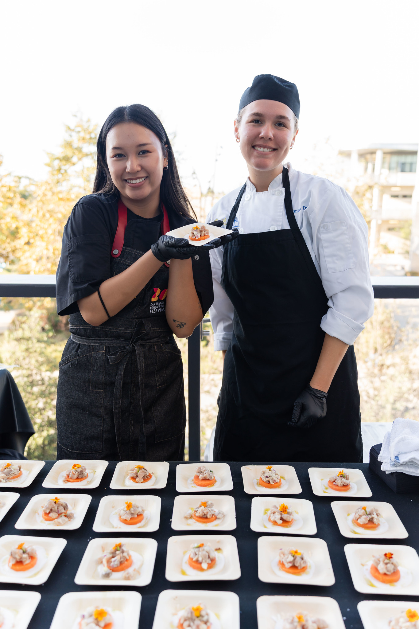 
Two chefs arrange tasting samples on a table.
