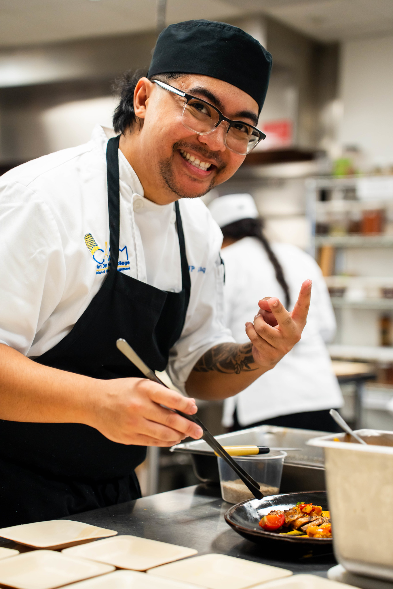 
A chef in the prep area assembling food samples.
