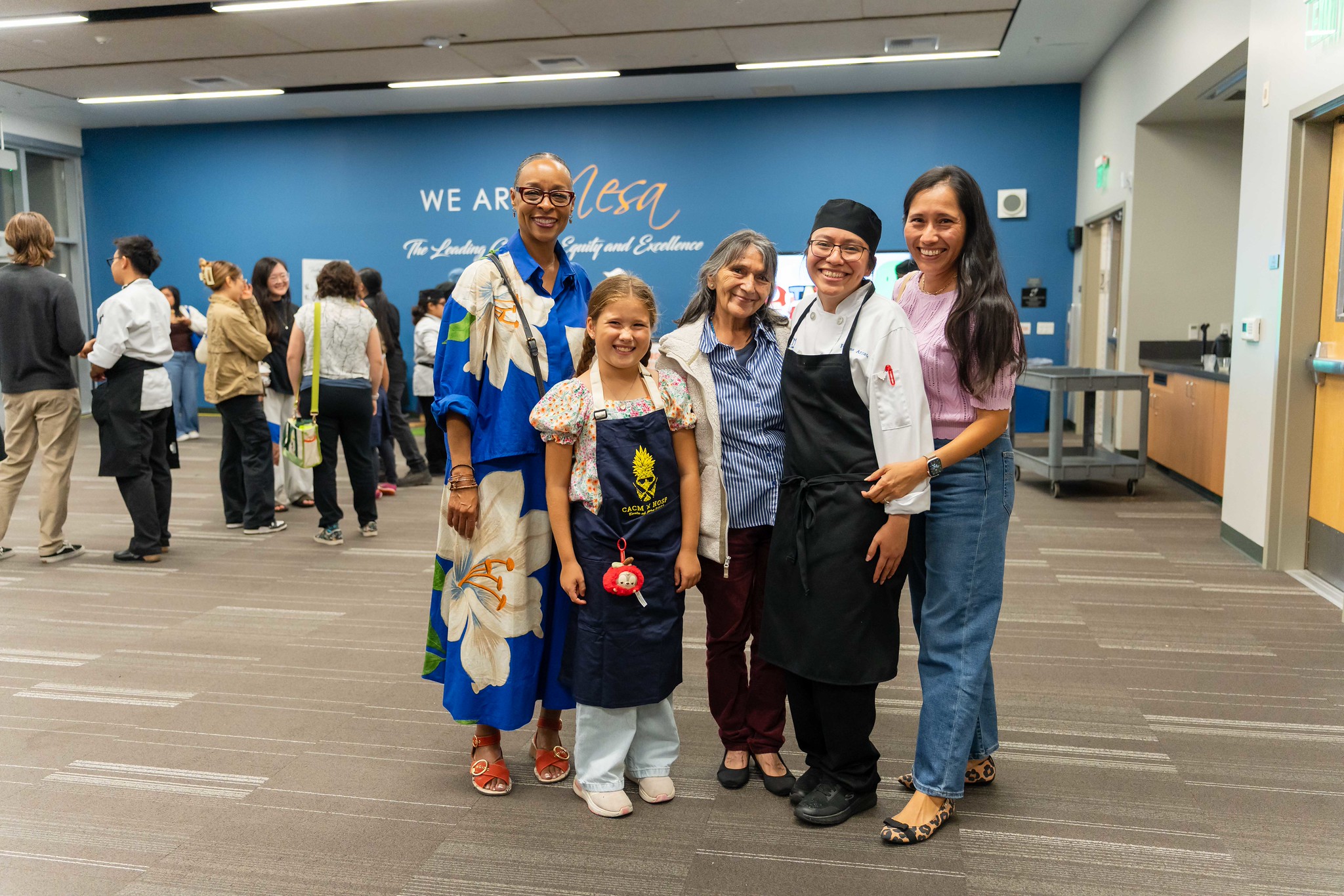 
Mesa College President Ashanti Hands with a chef and her family at Taste of Mesa.
