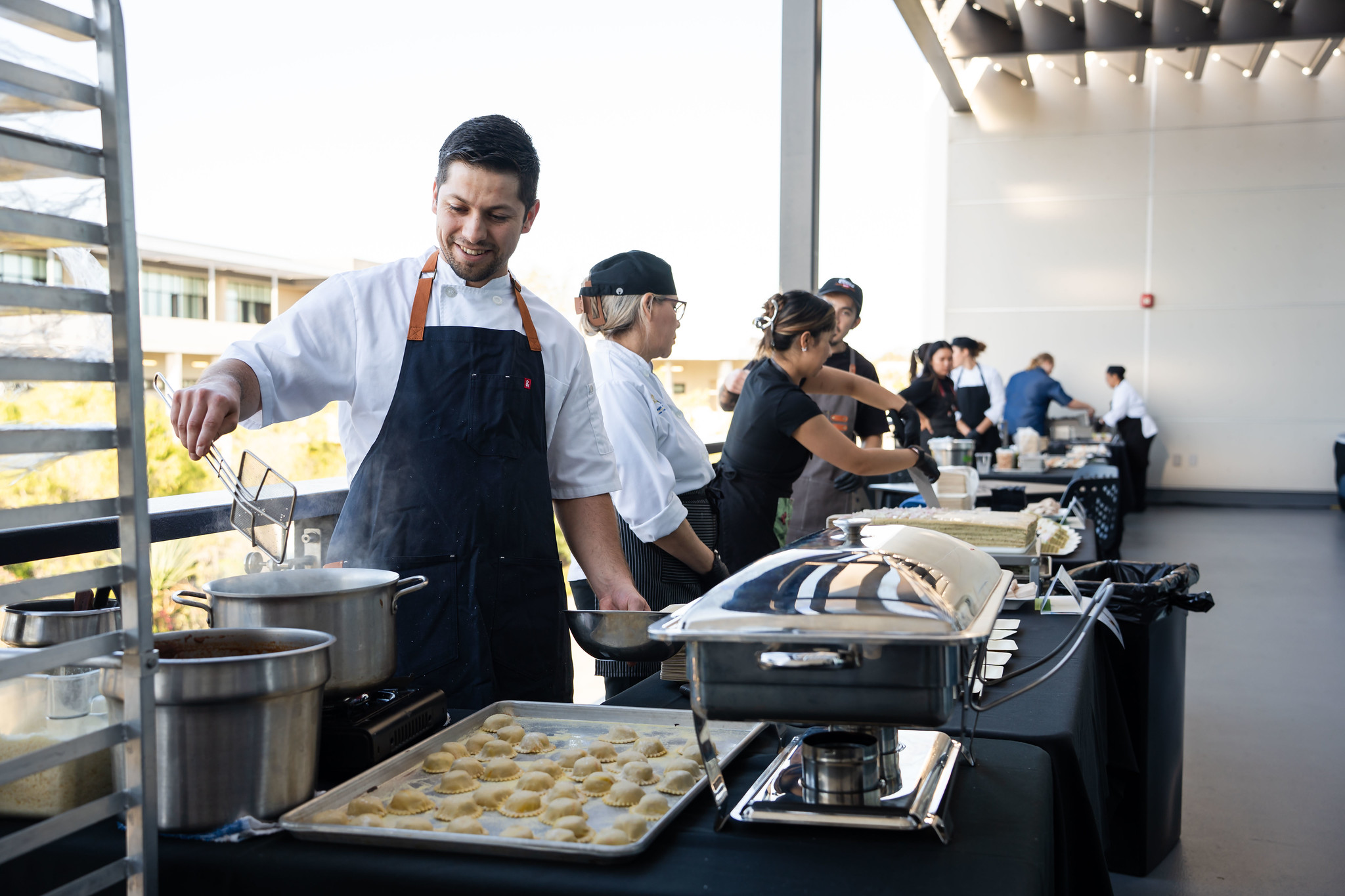 
A row of chefs at a serving station. 
