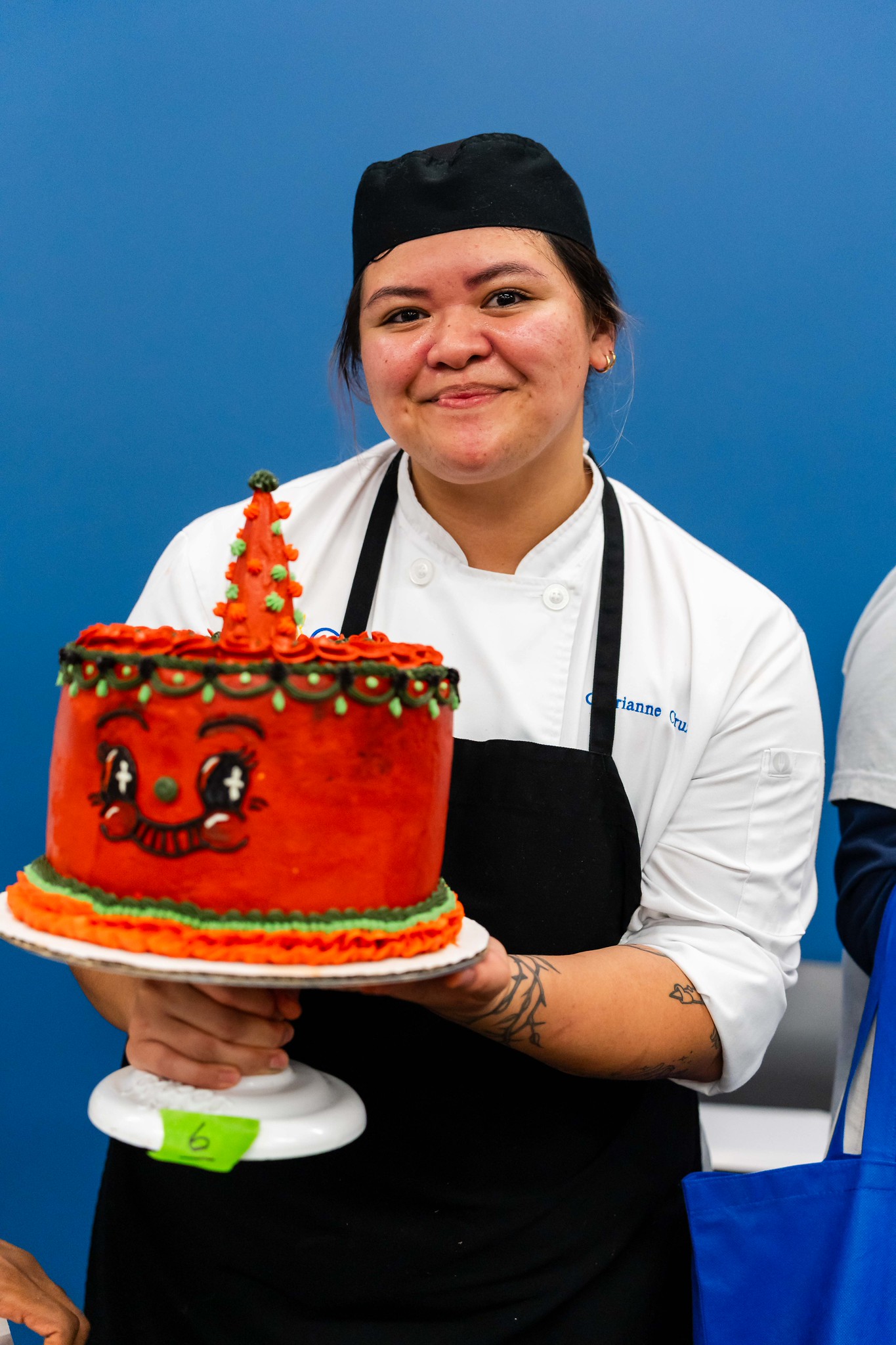 
A chef holds up her cake.
