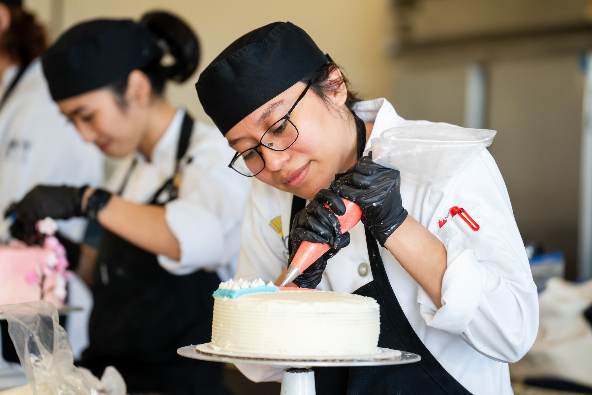 
A chef decorating a cake.
