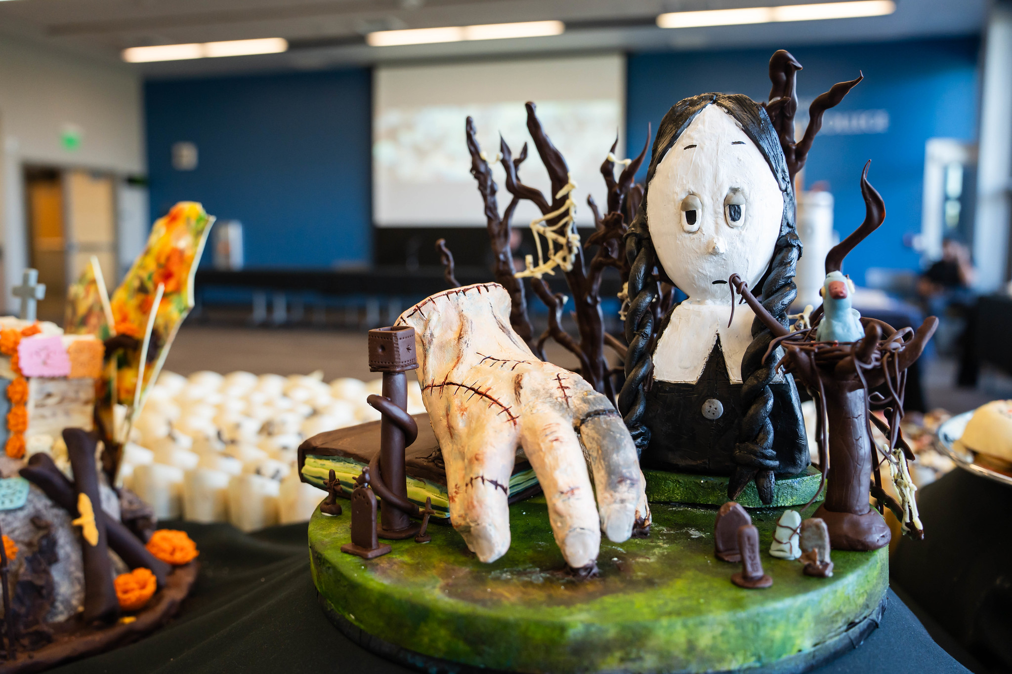
A Halloween themed cake with a witch and a hand with stitches.
