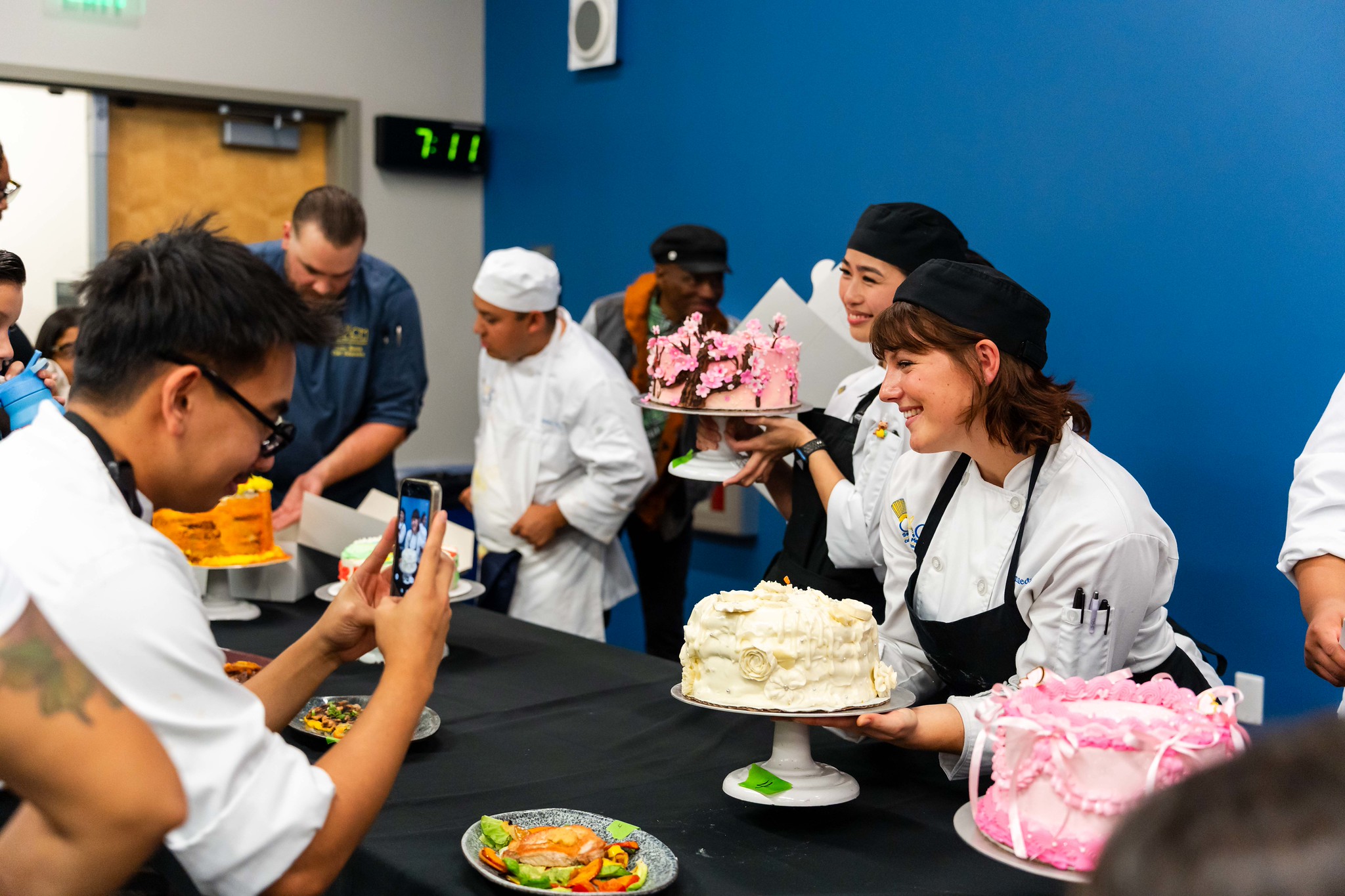
A row of chefs with their cakes.
