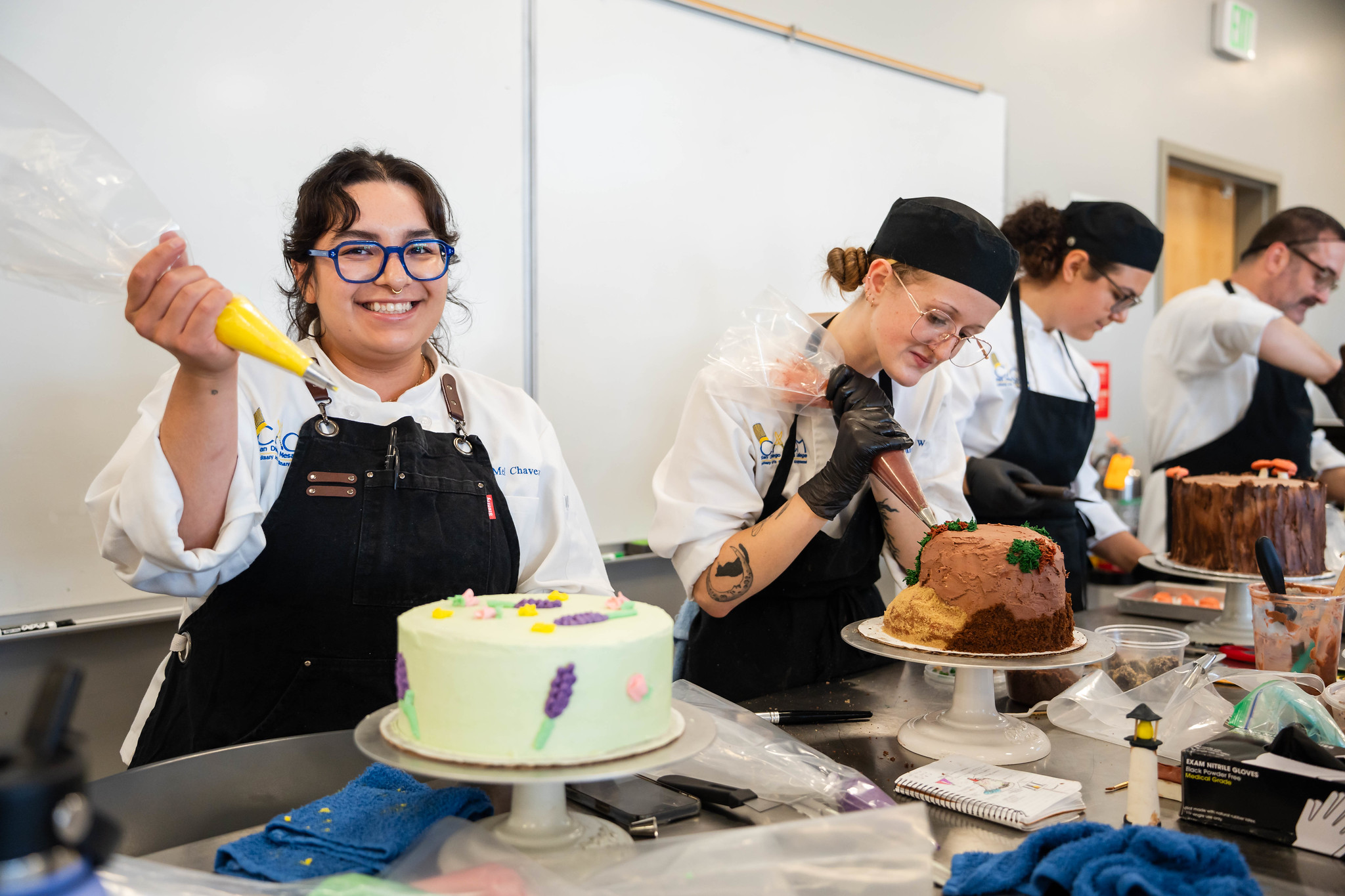 
A chef using a piping bag to decorate her cake. 
