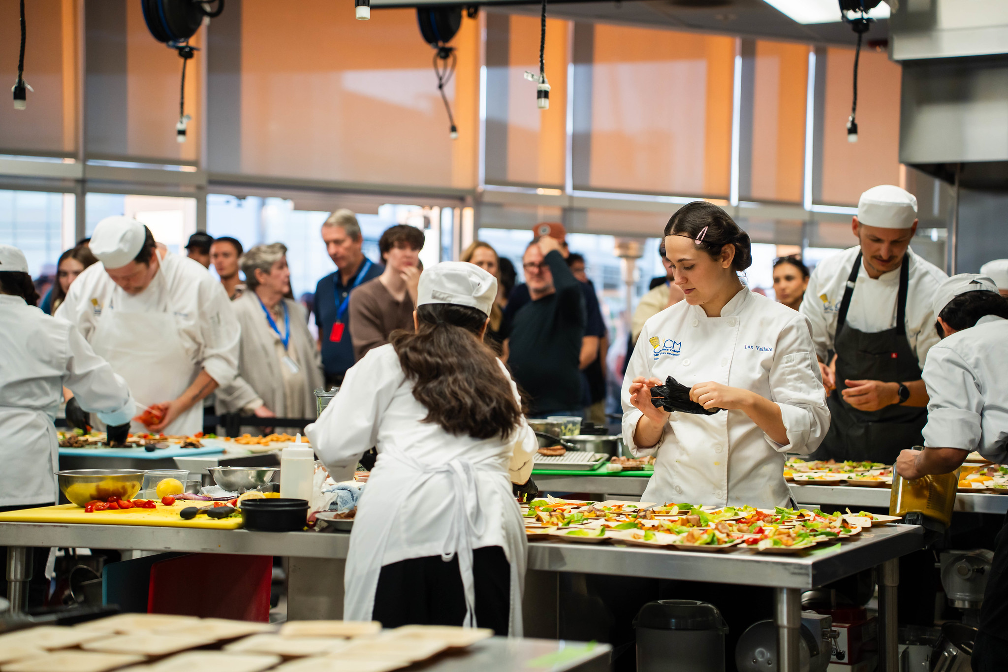 
A group of chefs at work stations preparing food samples. 
