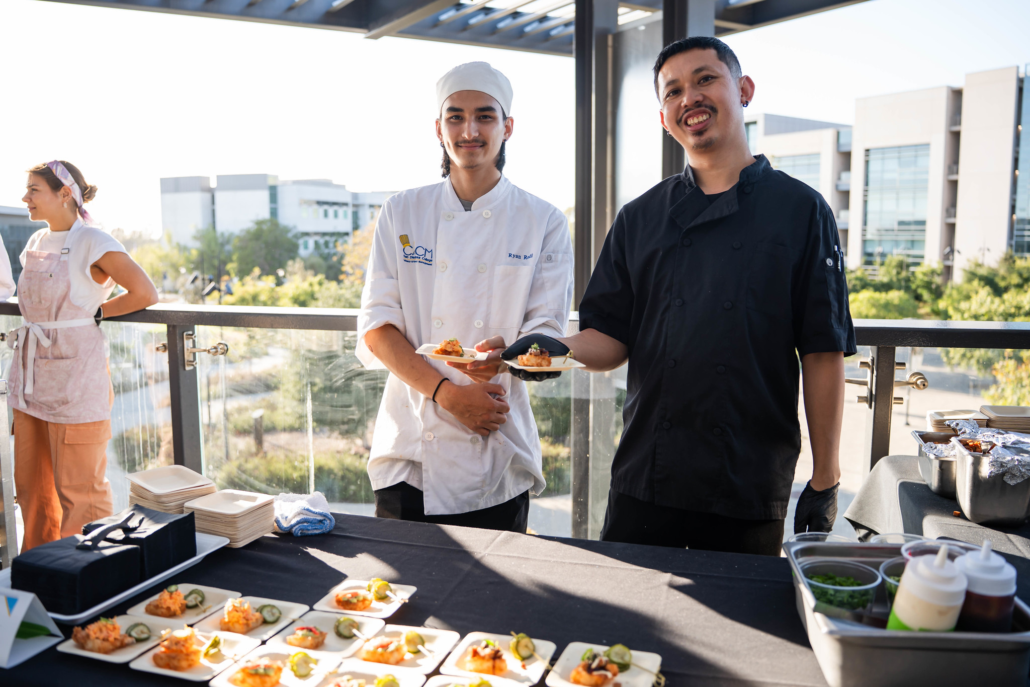 
Two chefs arrange tasting samples on a table
