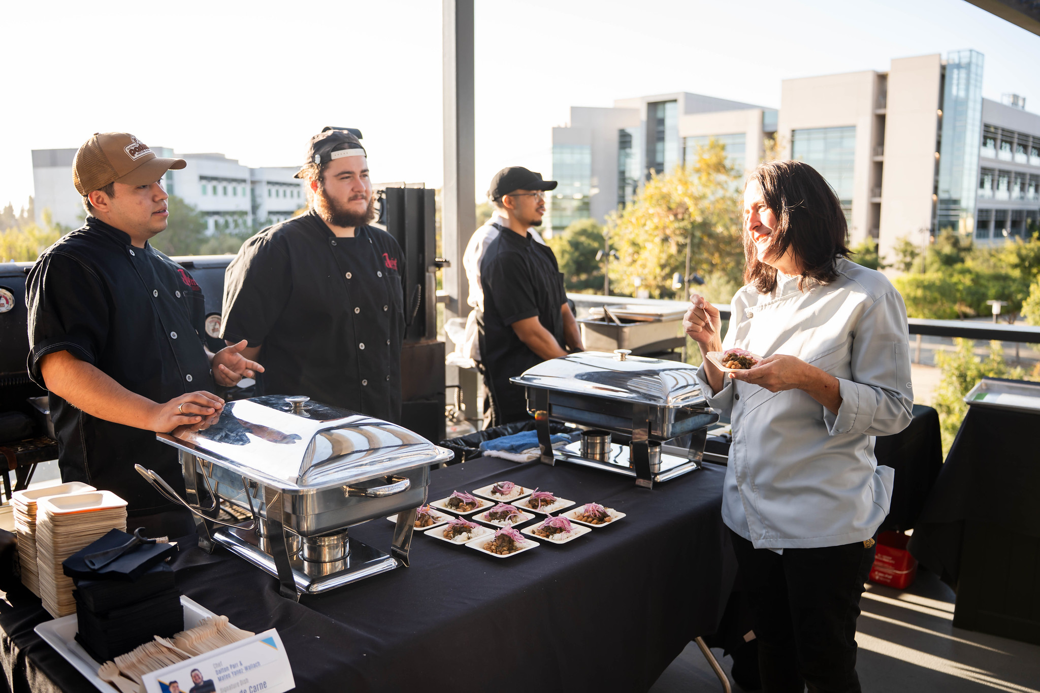 
Three chefs stand by a buffet table.
