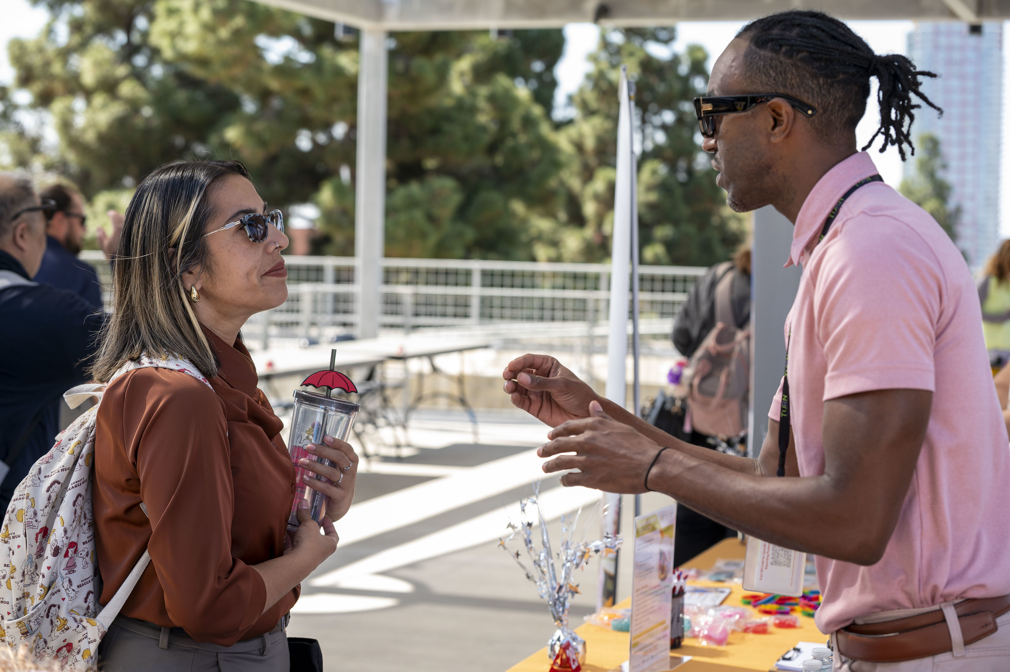 Two people speaking at a booth.&nbsp;