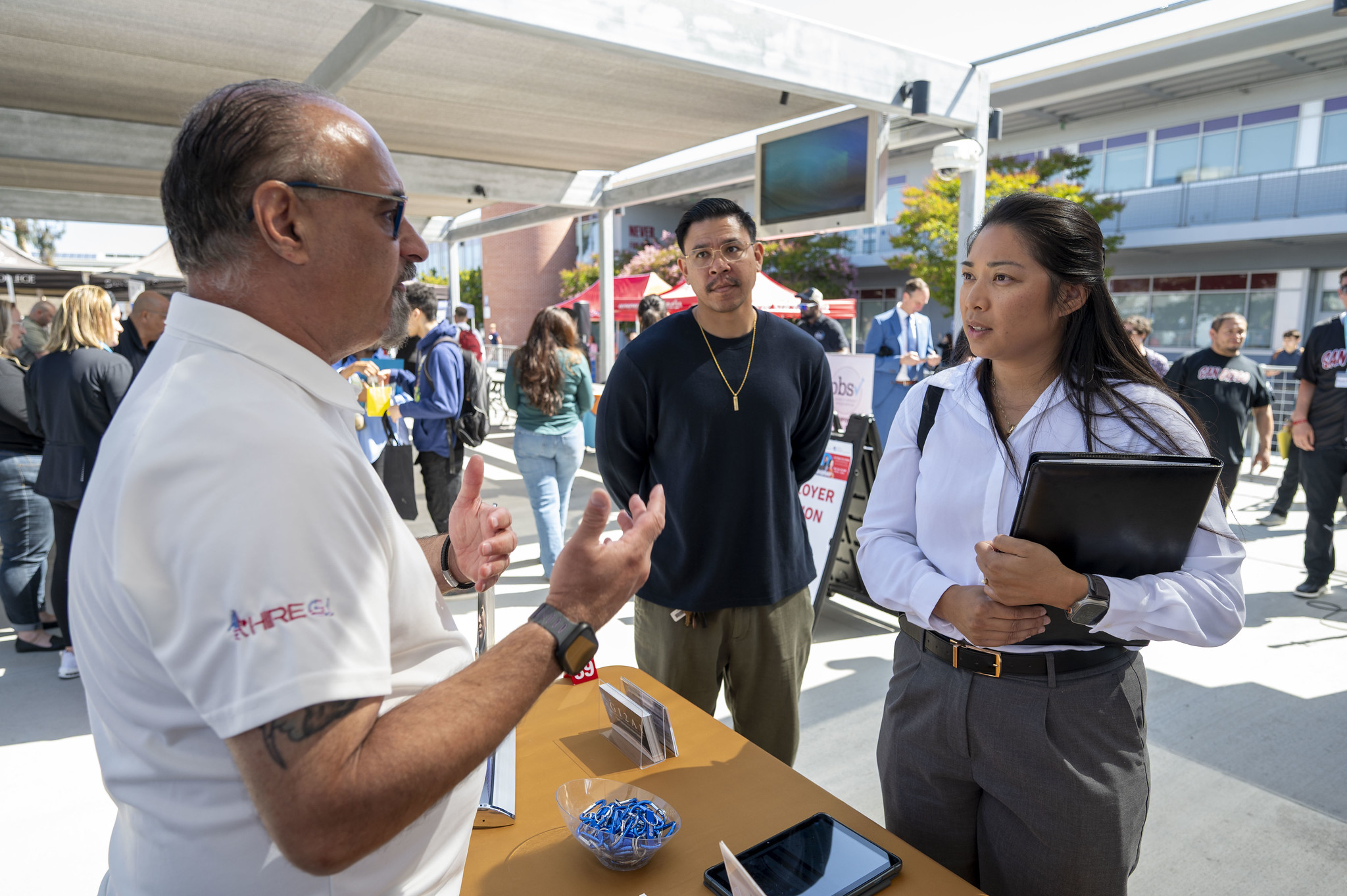 Two students stop by a booth at the career fair.