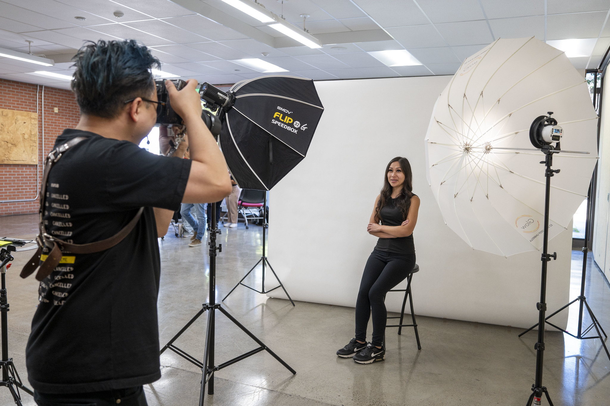 A photographer takes a student's photo for a professional headshot.